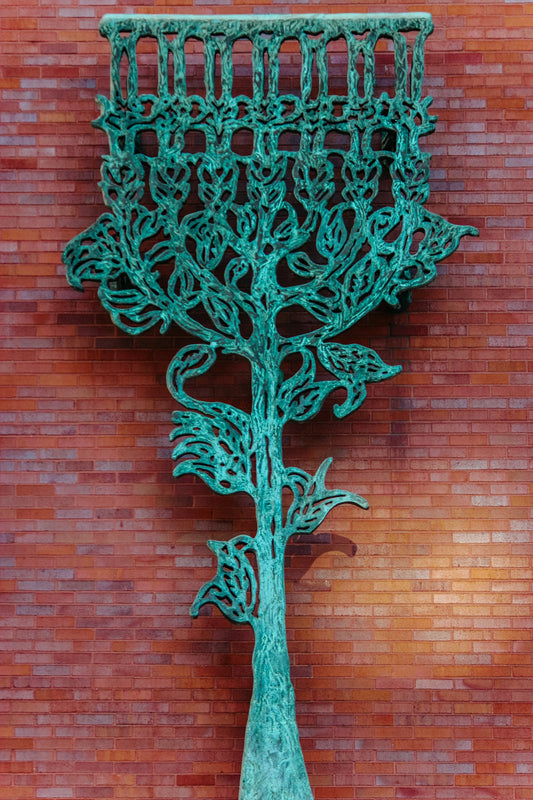 a sculpture of a menorah on a brick wall