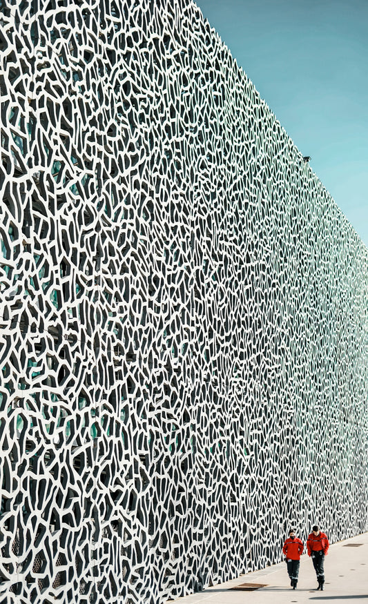 two people are walking in front of a wall
