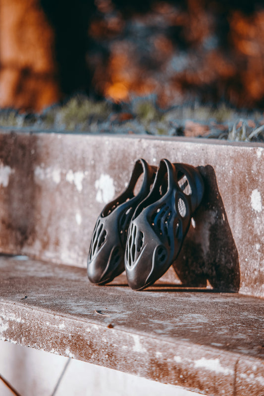 a pair of shoes sitting on top of a cement bench