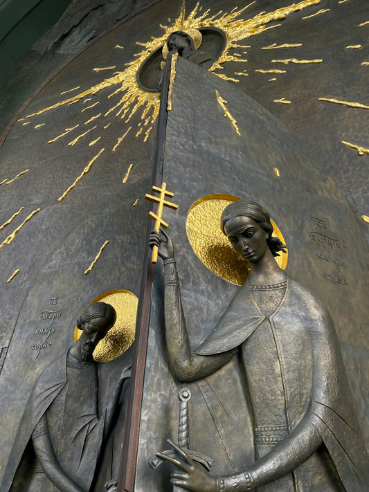 a statue of two people holding a pole