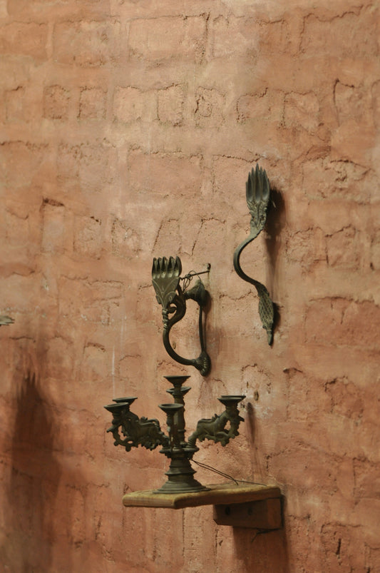 Antique candle holders and decorative pieces are on the wall.