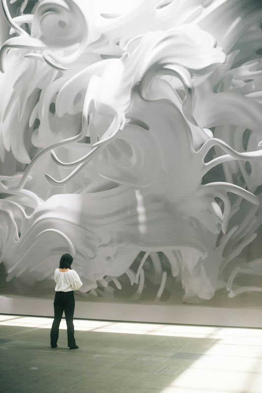 person in black jacket standing in front of white and gray wall