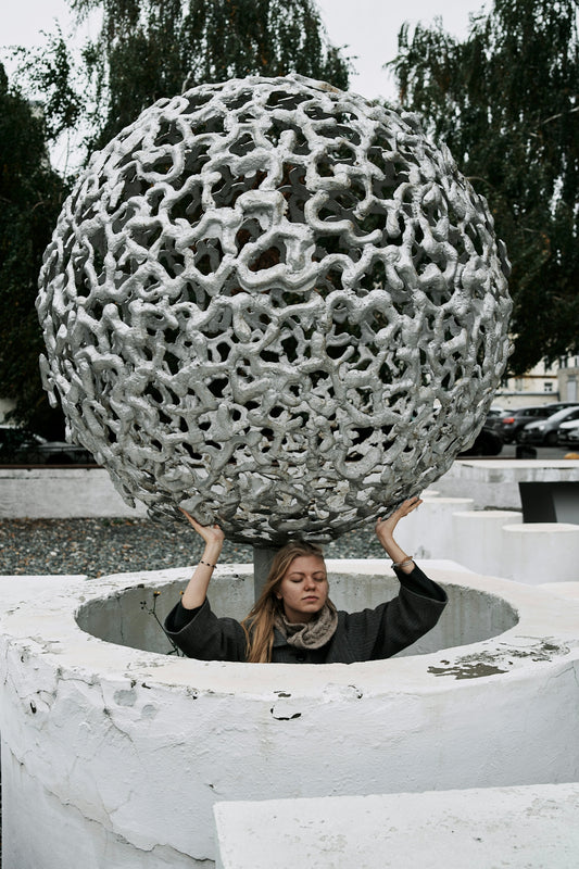 a woman holding a large metal object over her head