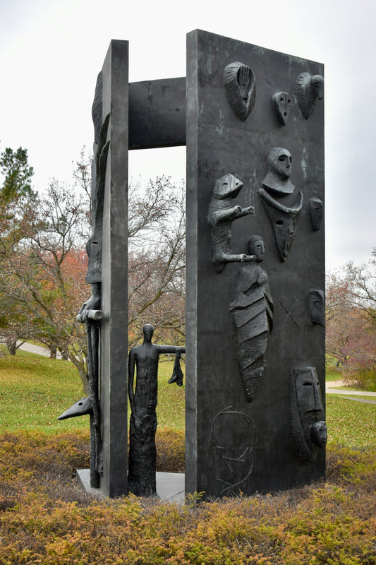 a sculpture of a man standing in front of a door