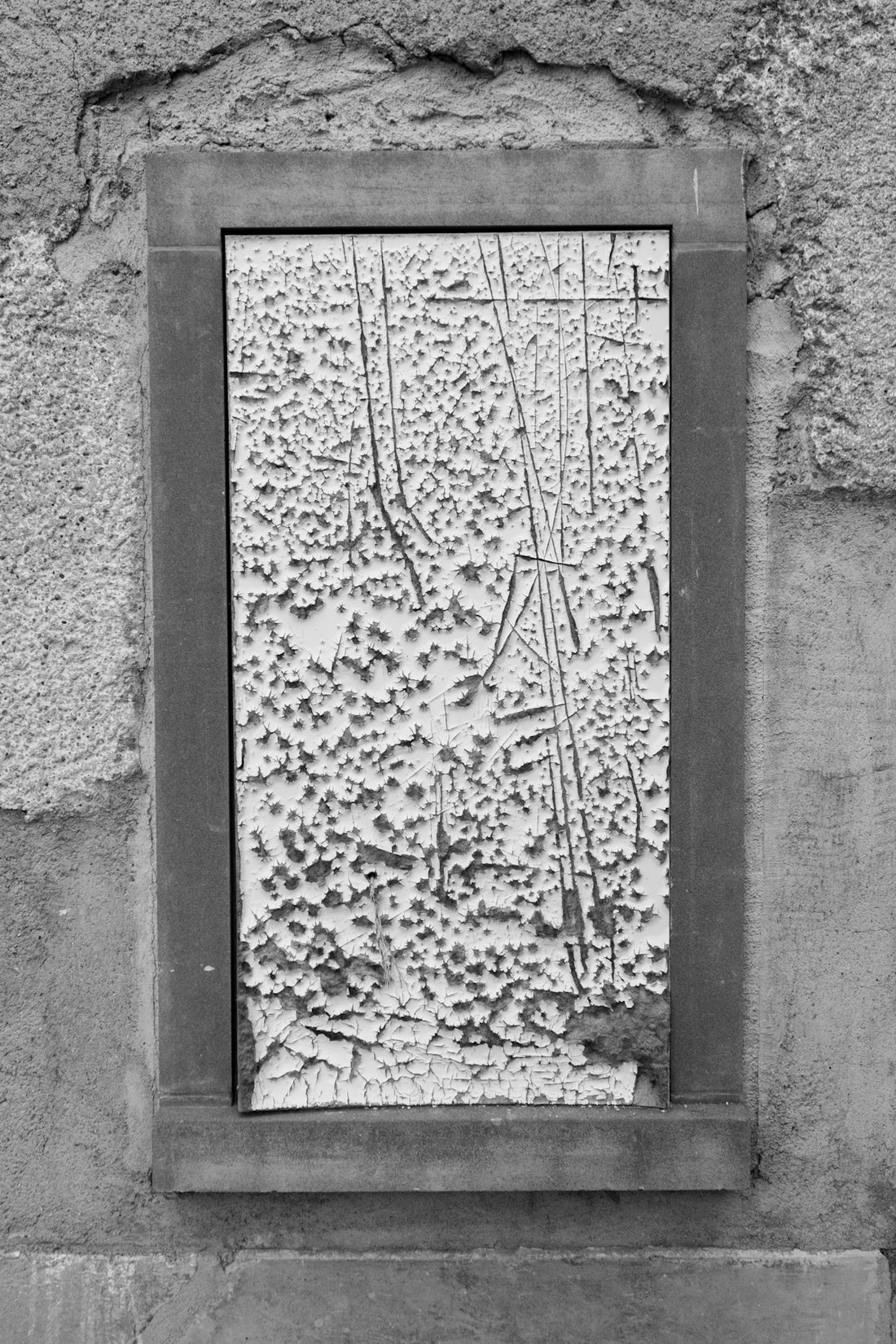 a black and white photo of a window in a wall