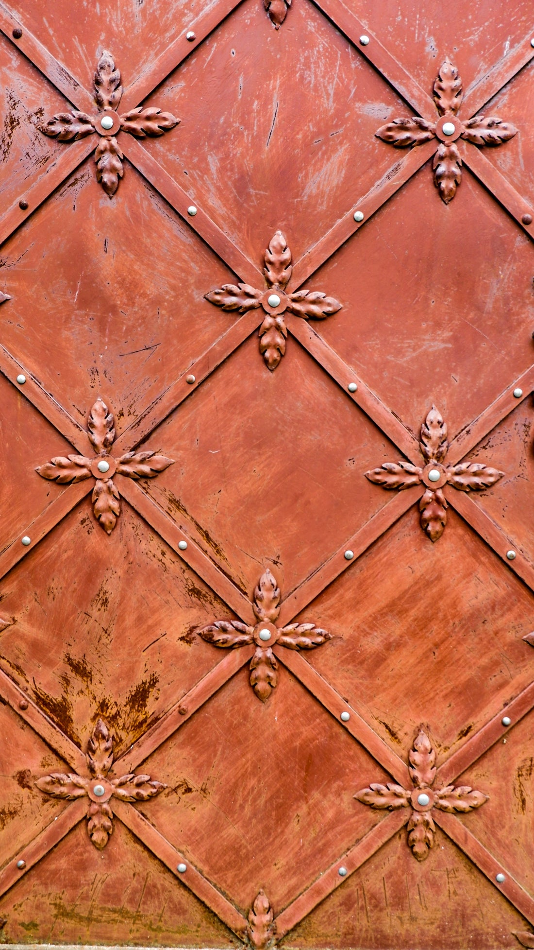 a close up of a metal surface with a clock on it