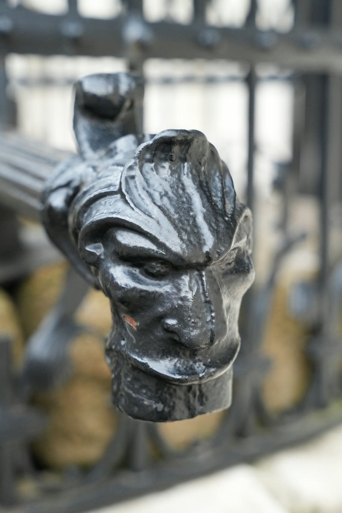 a sculpture of a man's head hanging from a fence