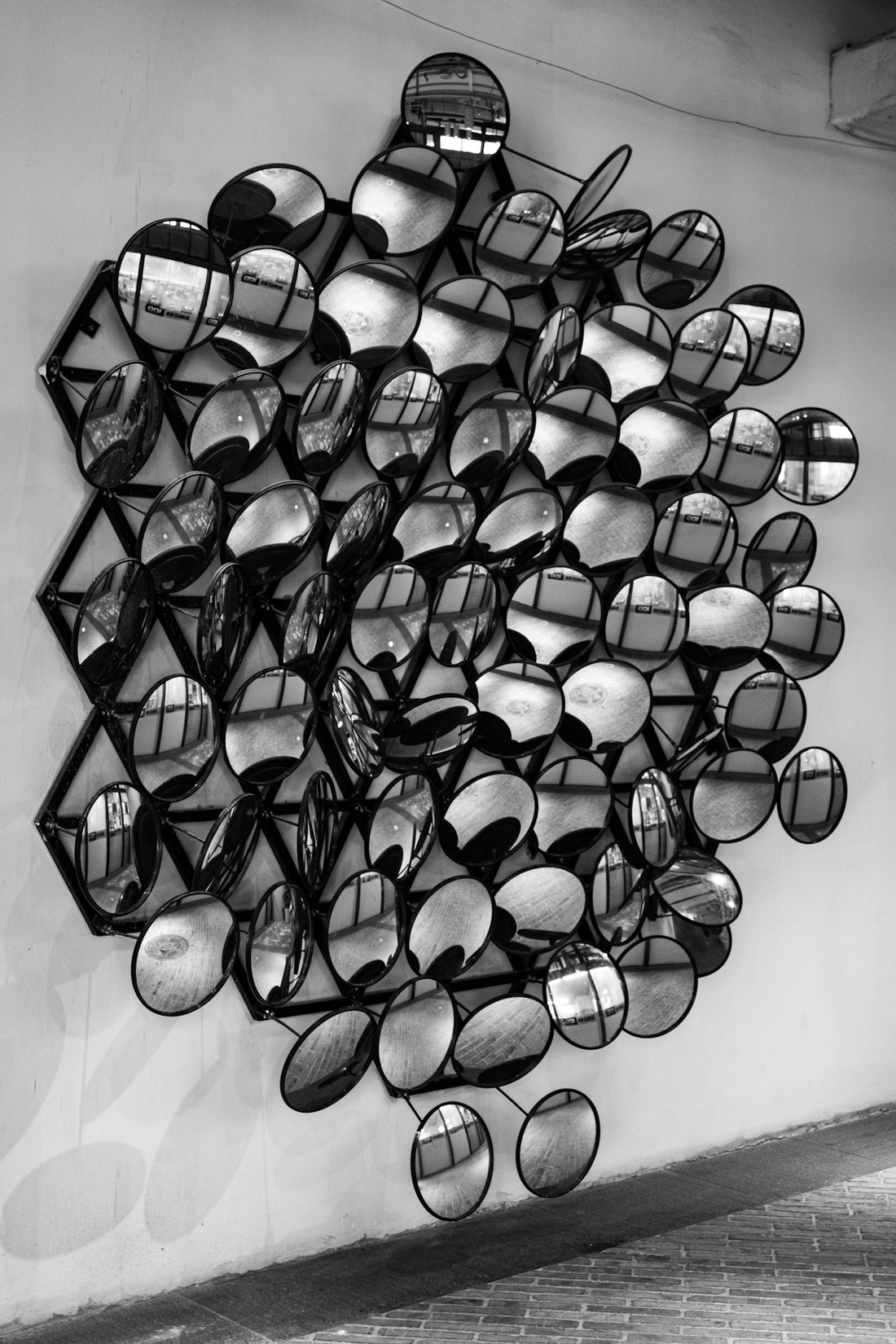 a black and white photo of a bunch of glasses hanging on a wall