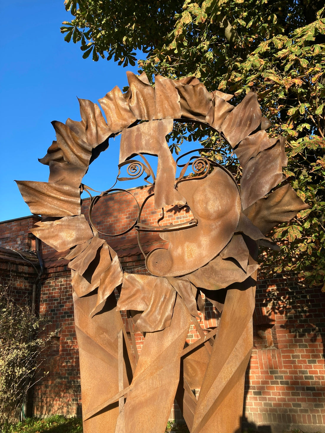 A sculpture of a woman's face in front of a building
