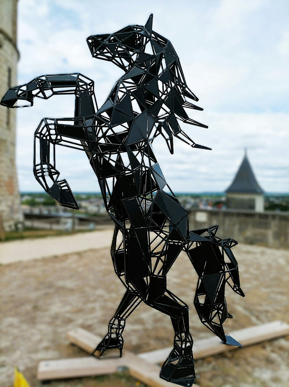 A sculpture of a horse on a wooden platform
