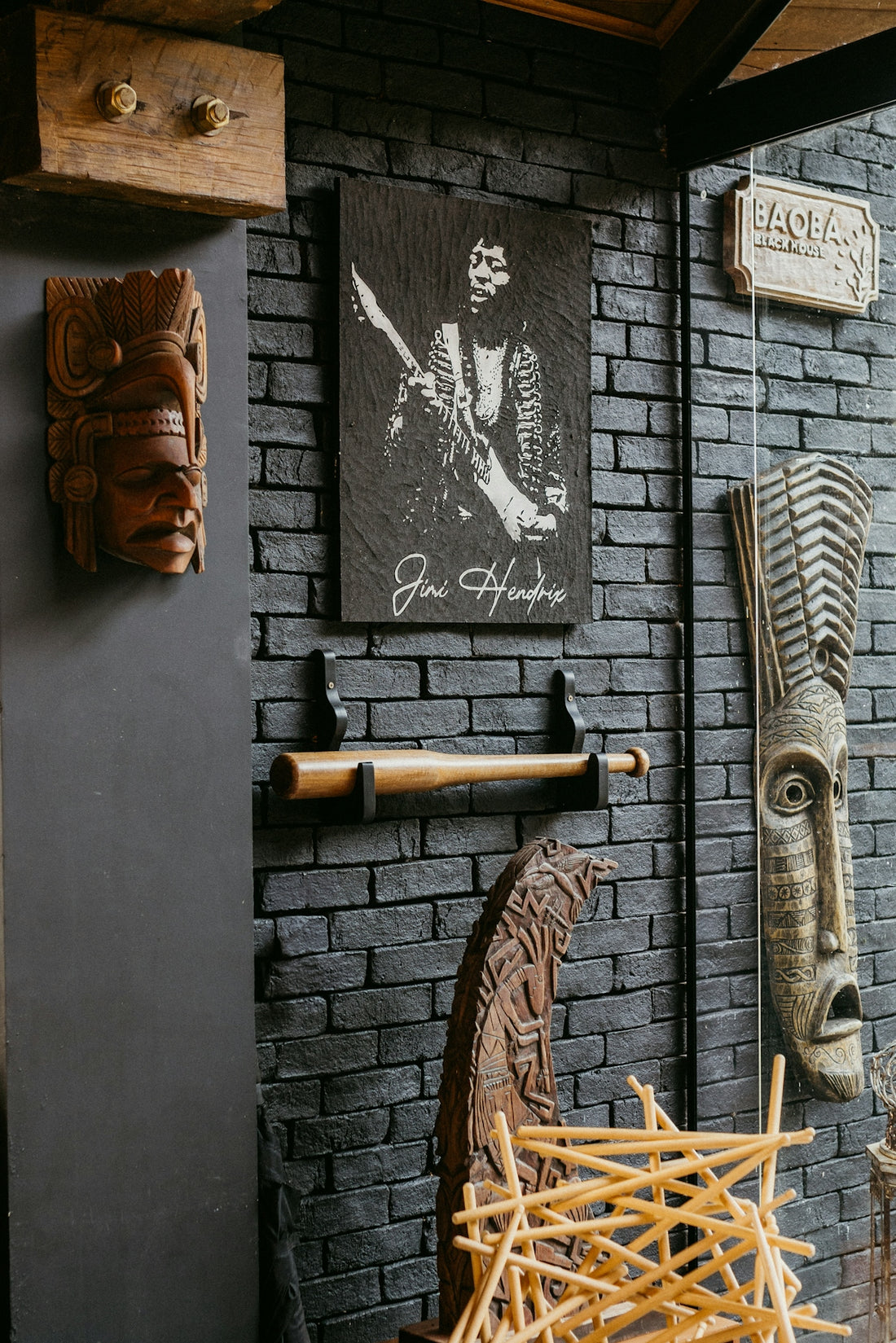 A room with a brick wall and wooden sculptures