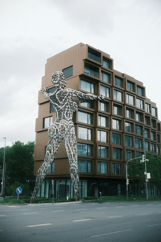 A giant sculpture stands by a modern building.