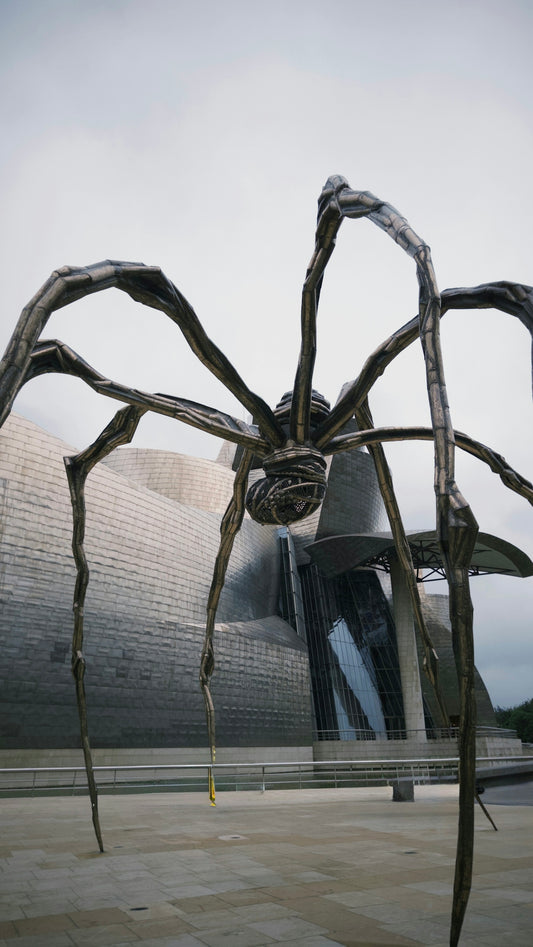 A giant spider sculpture stands in front of a building.