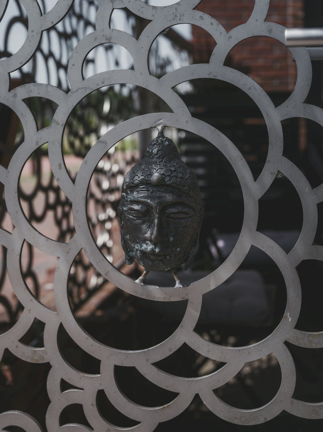 A statue is seen through an ornate metal design