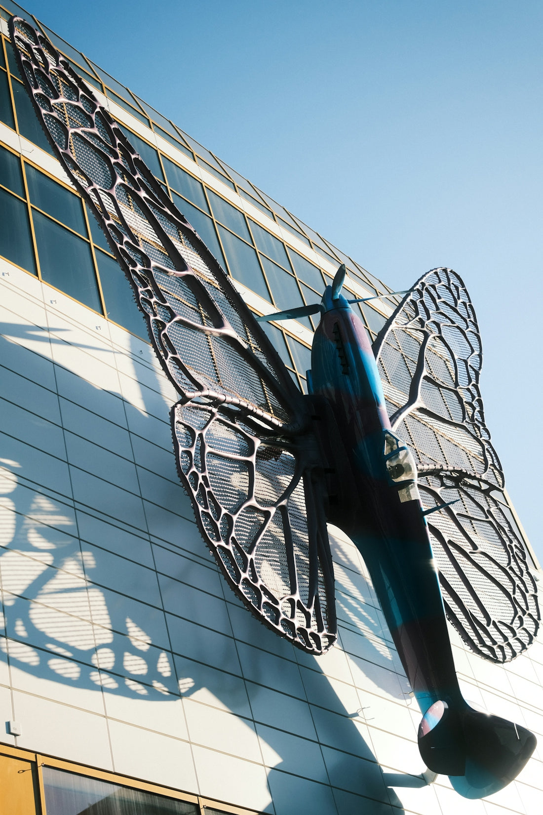 Airplane sculpture with butterfly wings on building