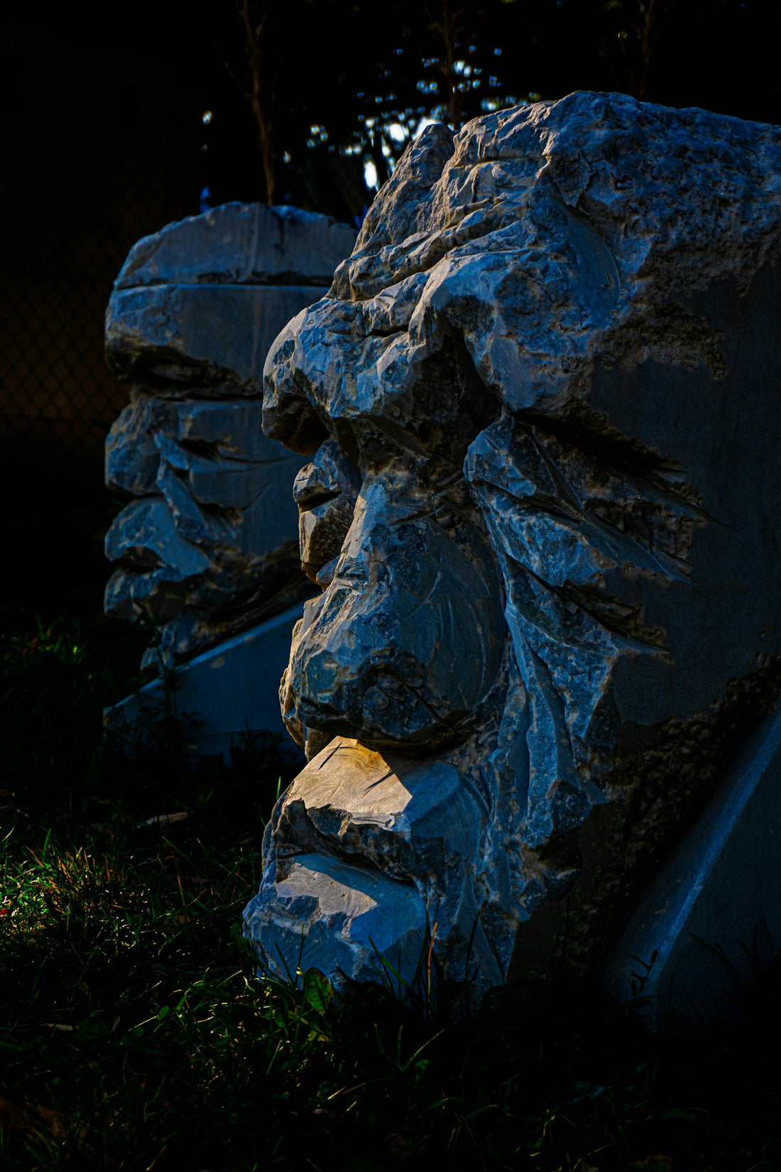 Two stone heads carved from rough rock