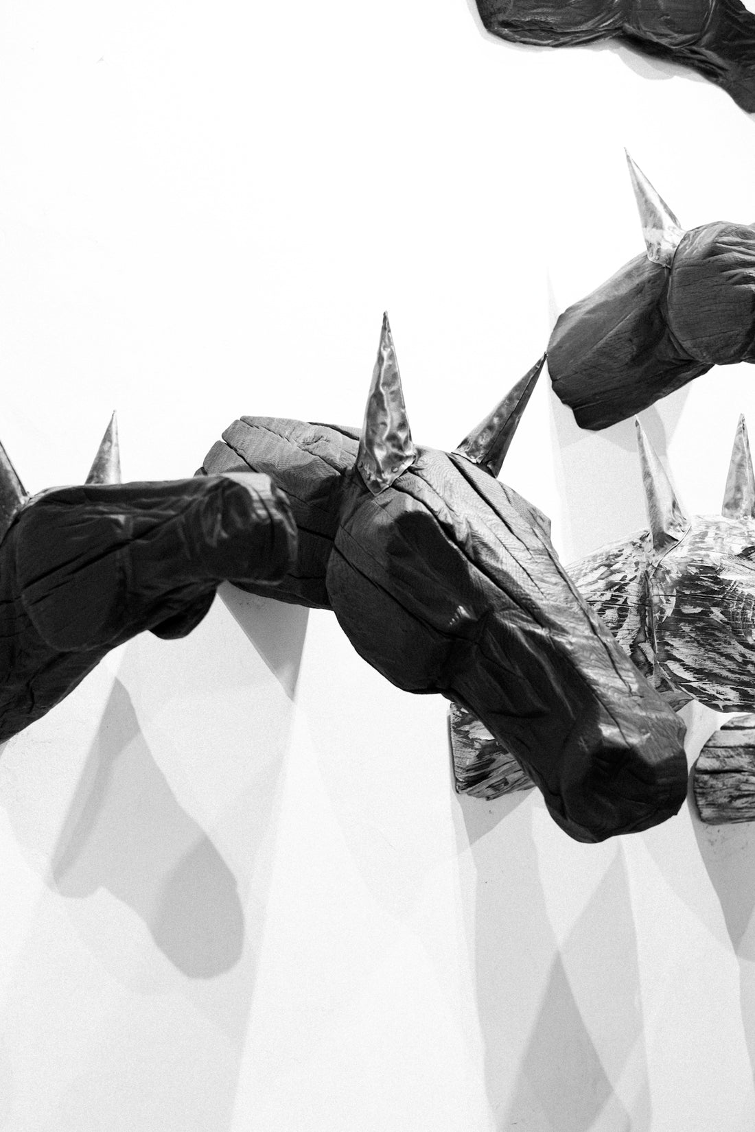 Sculptural horse heads mounted on a wall.