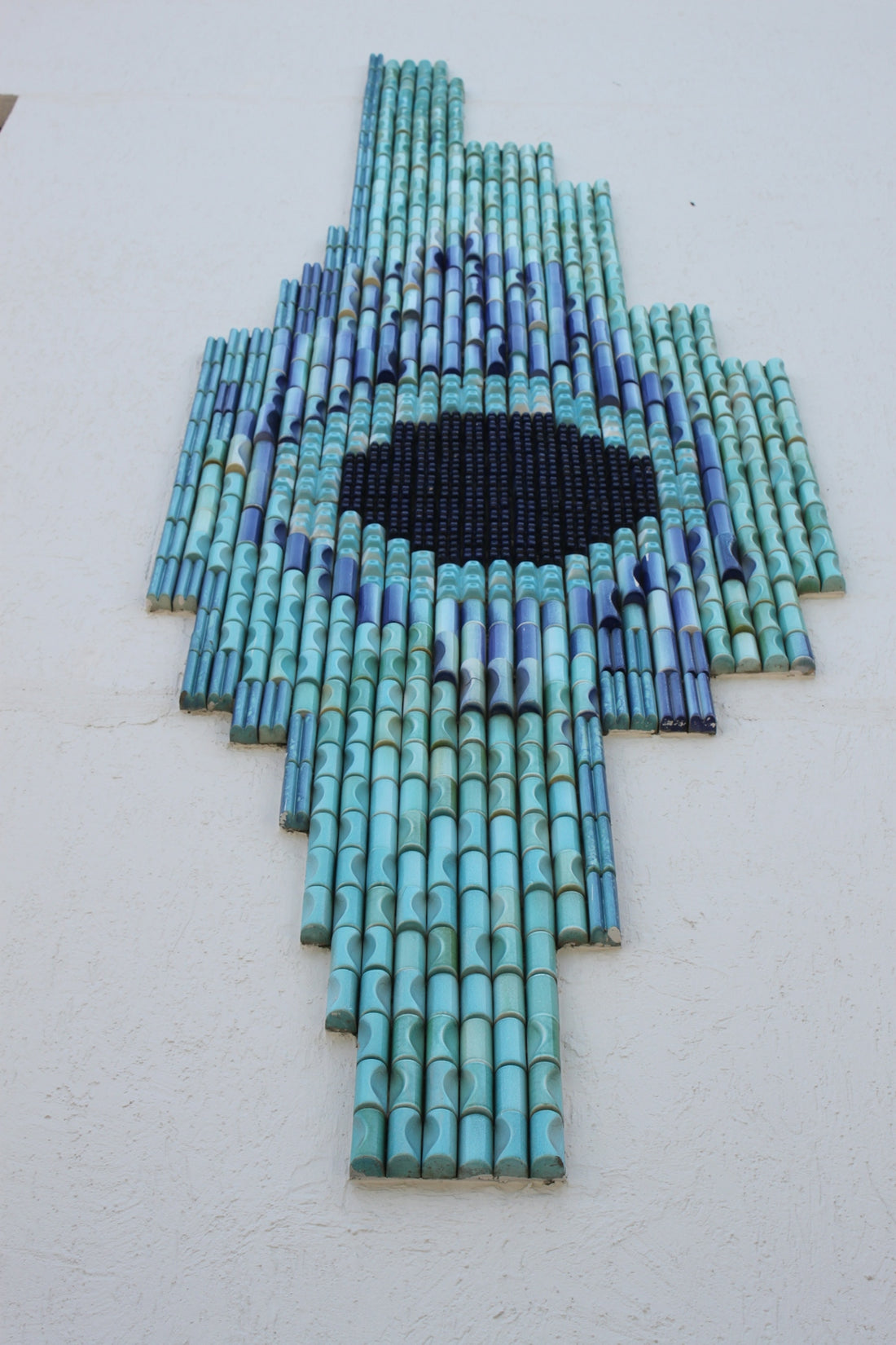 Abstract blue and black mosaic art on white wall