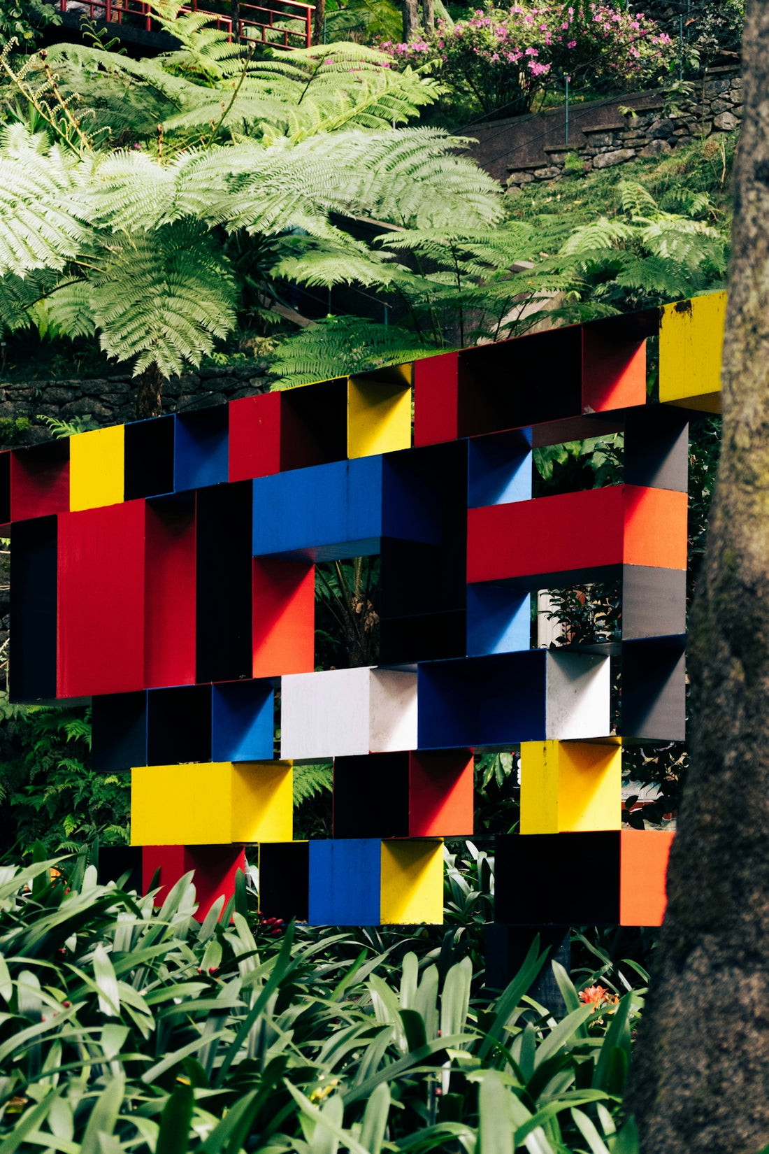 Colorful geometric art installation in lush greenery