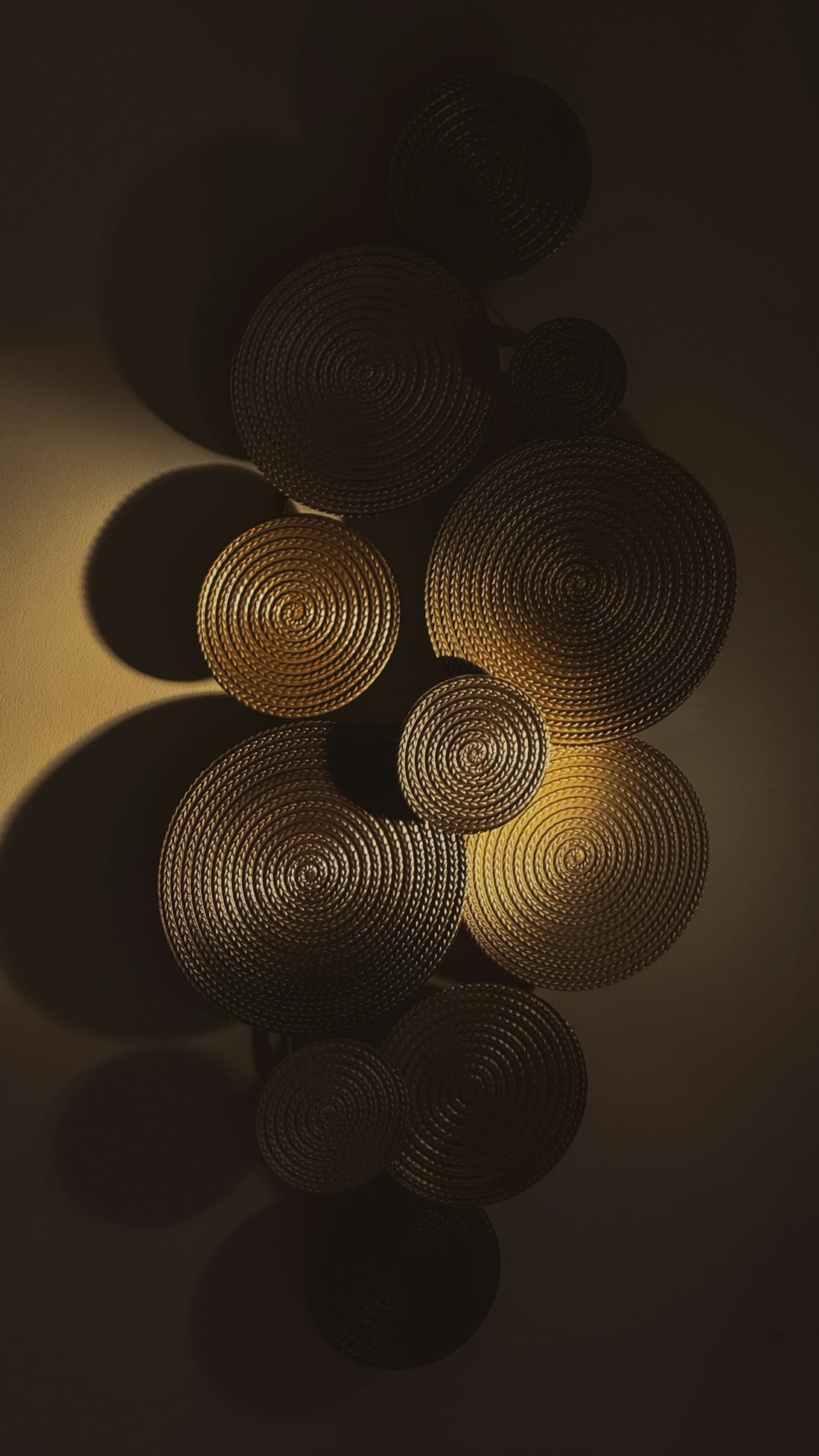Circular textured wall art with dramatic shadows
