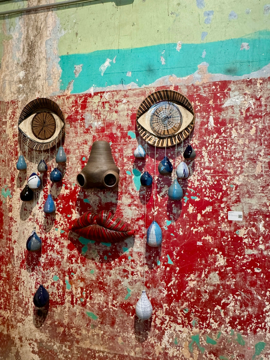 Abstract art installation resembling a face with tears