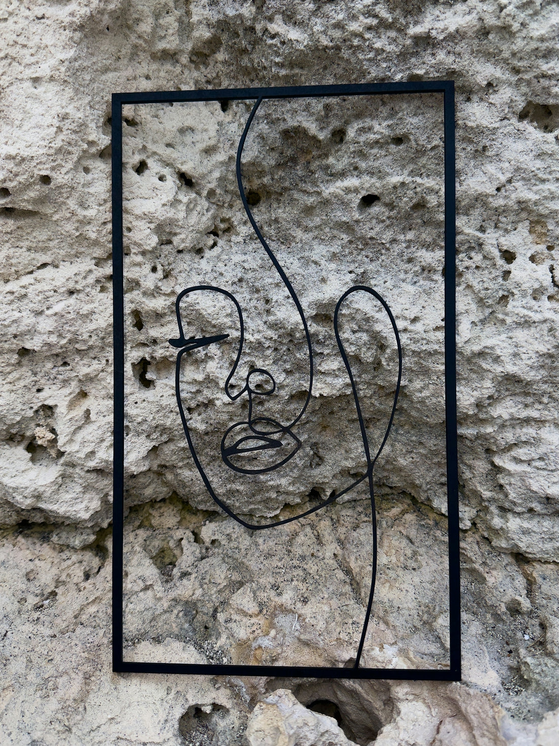Abstract line art of a face on a stone wall