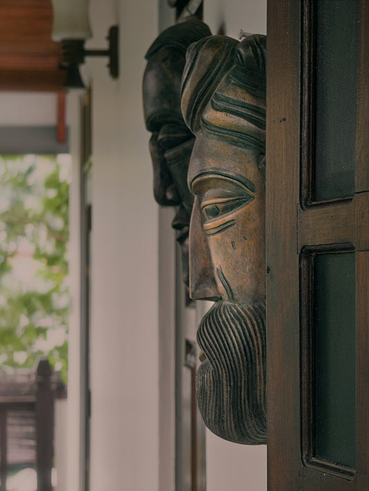 Wooden carved faces adorn a wall