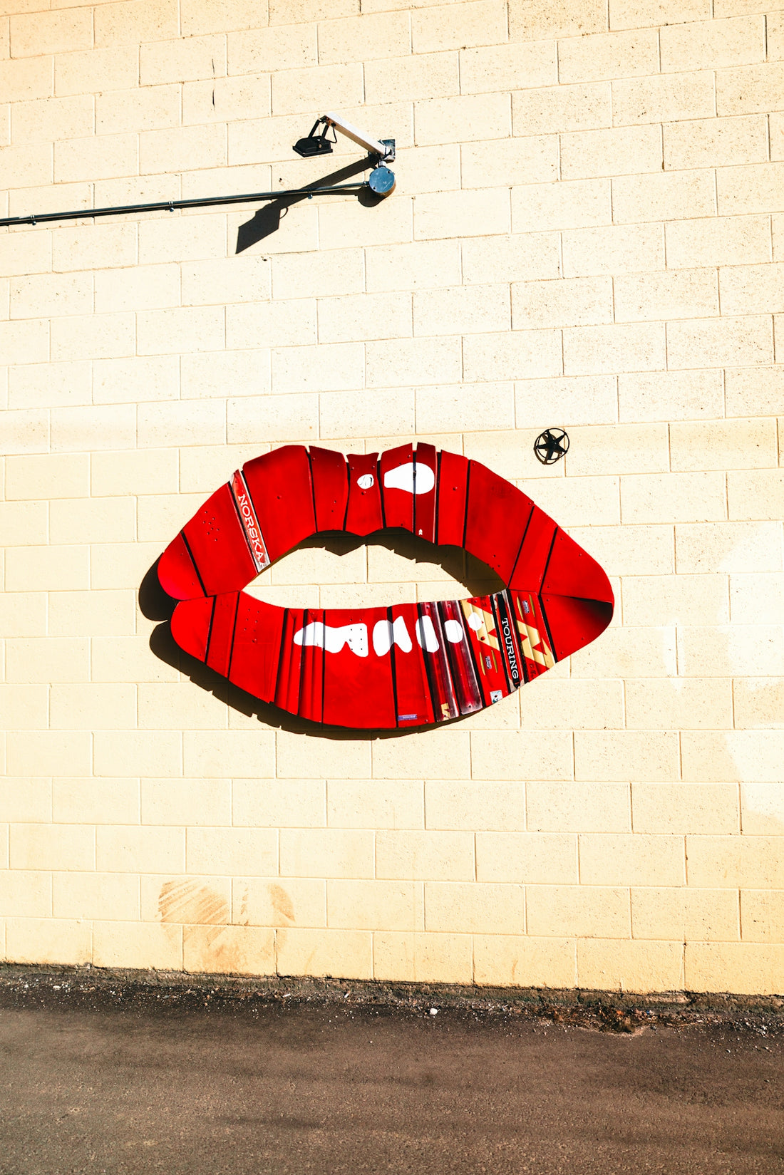 Large red lips painted on a brick wall