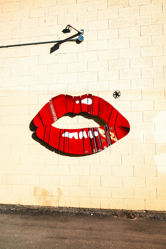 Large red lips painted on a brick wall