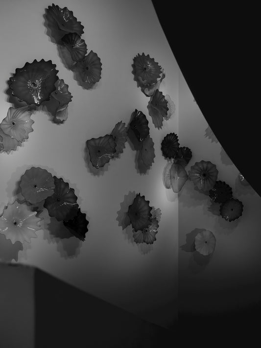 Several decorative glass flower sculptures on wall.