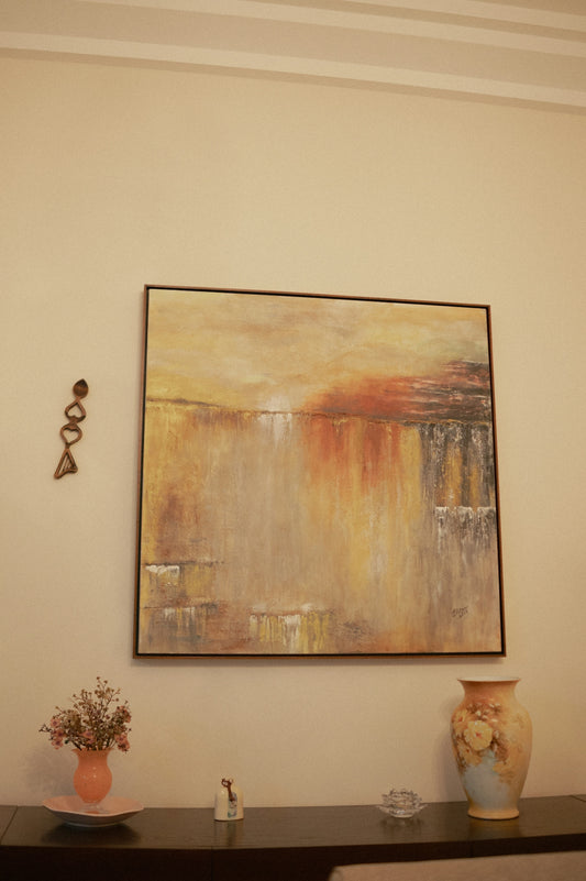 Abstract painting with warm colors above a vase.