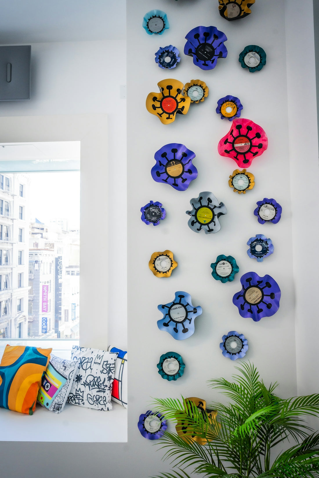 Vibrant flower art adorns a white wall beside a window