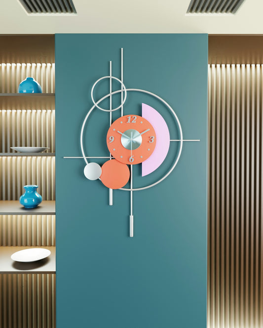 A modern geometric wall clock with orange and pink accents on a teal wall